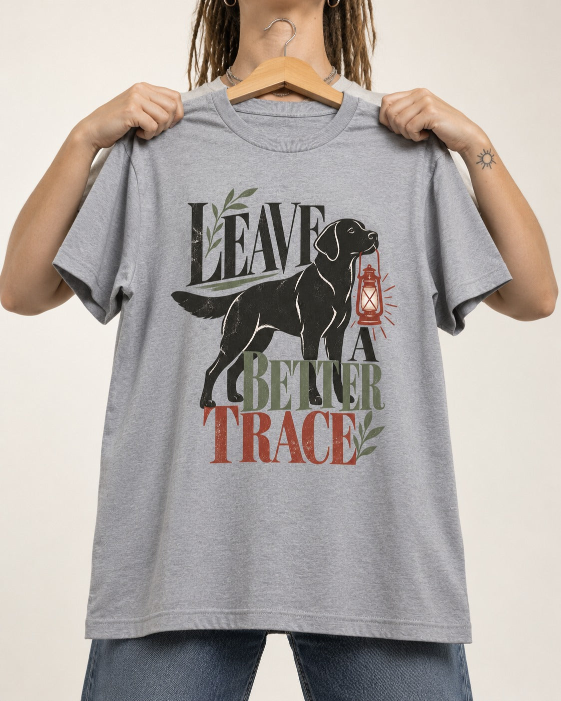 Leave a Better Trace Labrador Retriever T-Shirt in Sport Grey, held up on a hanger