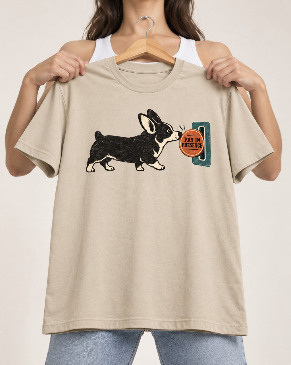 Corgi Pay in Presence T-Shirt in Sand, held up on a hanger