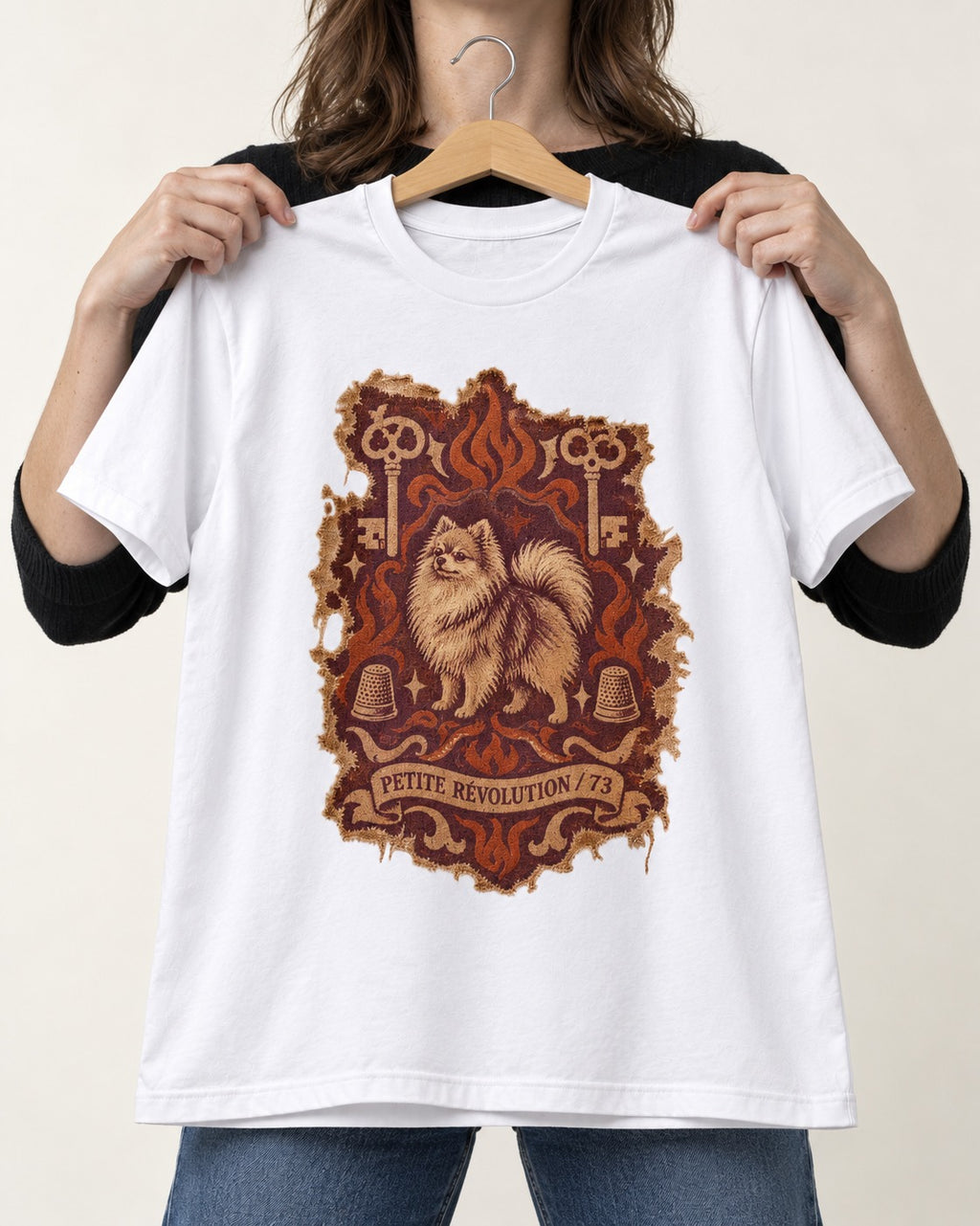 Pomeranian Petite Revolution Ornate Key Emblem Graphic T-Shirt in White, held up on a hanger
