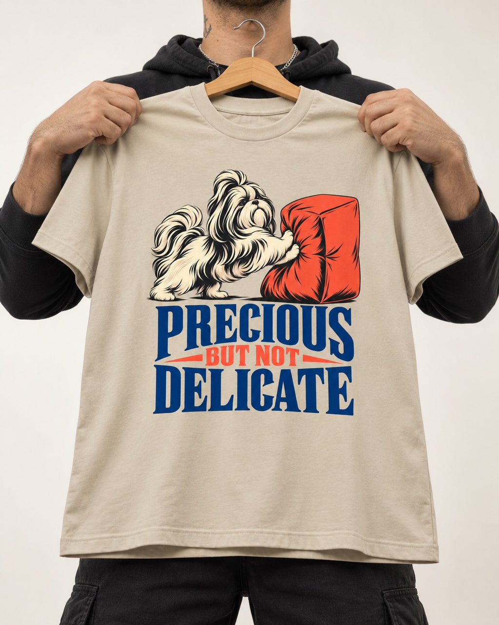 Precious but Not Delicate Shih Tzu T-Shirt in Sand, held up on a hanger