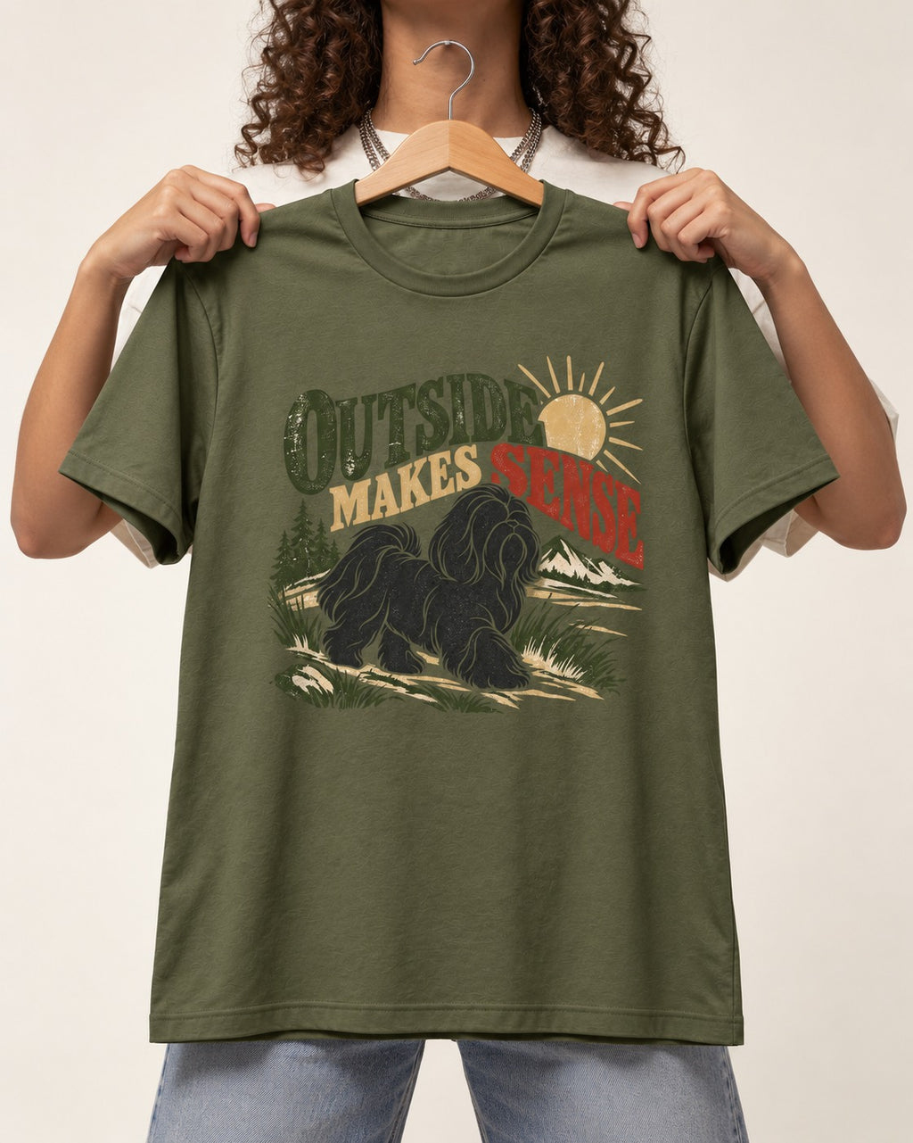 Shih Tzu Outside Makes Sense Mountain Trail Graphic T-Shirt in Heather Military Green, held up on a hanger