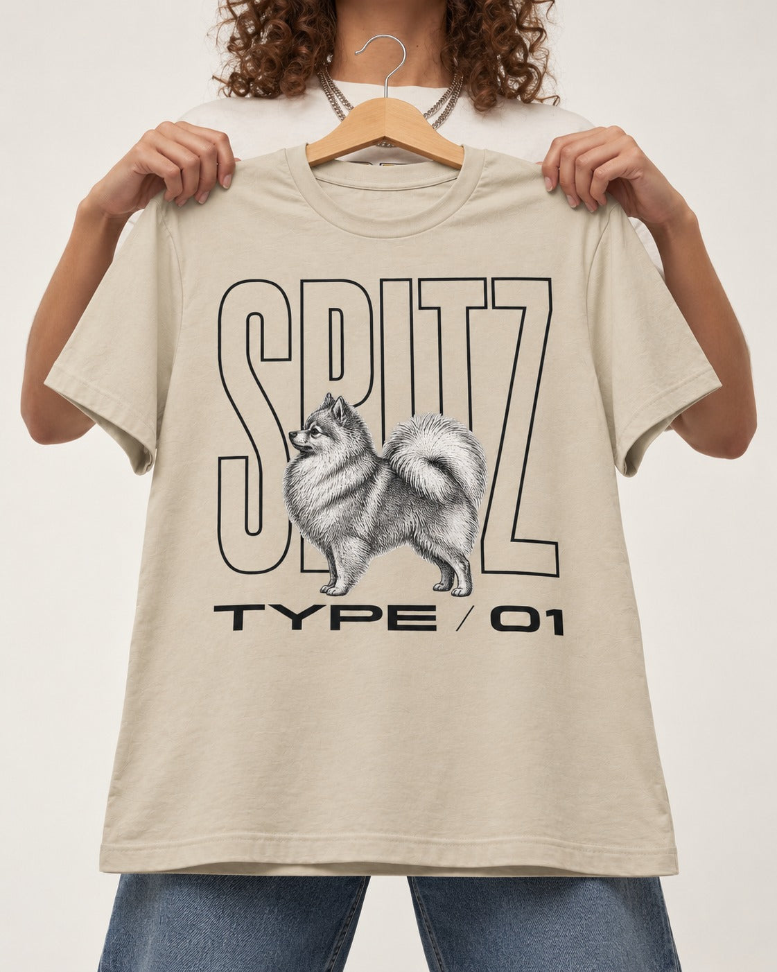 Pomeranian Spitz T-Shirt in Sand, held up on a hanger