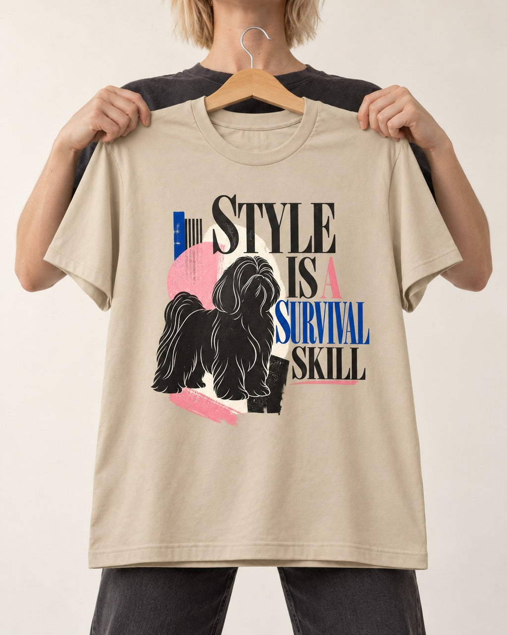 Shih Tzu Survival Skill T-Shirt in Sand, held up on a hanger