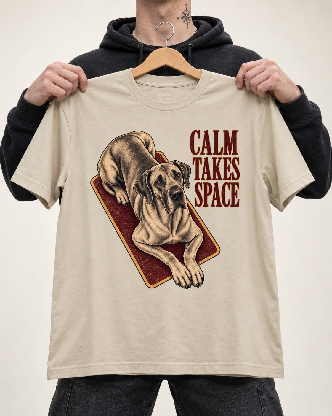 Great Dane Calm Takes Space T-Shirt in Sand, held up on a hanger
