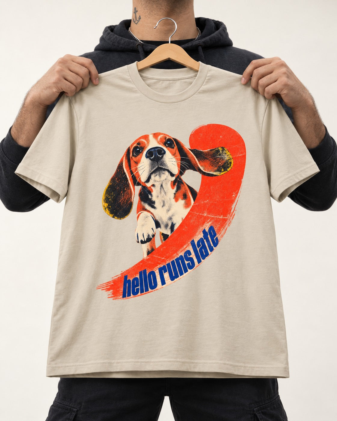 Beagle Hello Runs Late T-Shirt in Sand, held up on a hanger