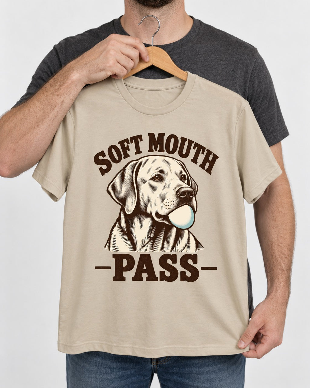 Soft Mouth Pass Labrador Retriever T-Shirt in Sand, held up on a hanger