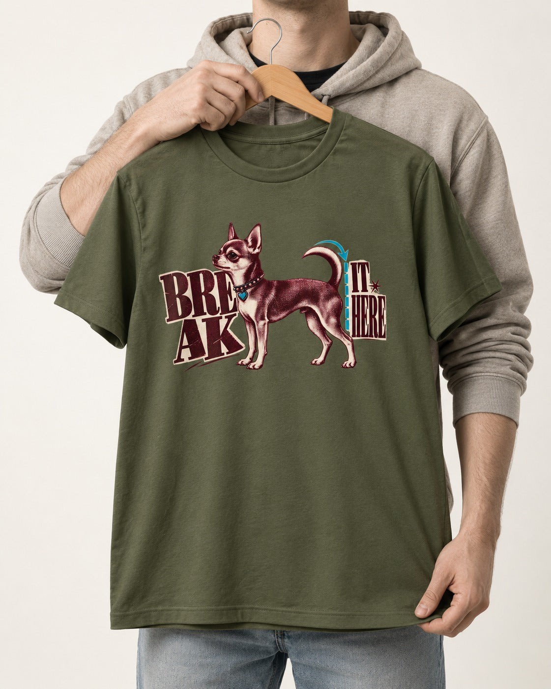Chihuahua Break It Here Perforation Graphic T-Shirt in Heather Military Green, held up on a hanger