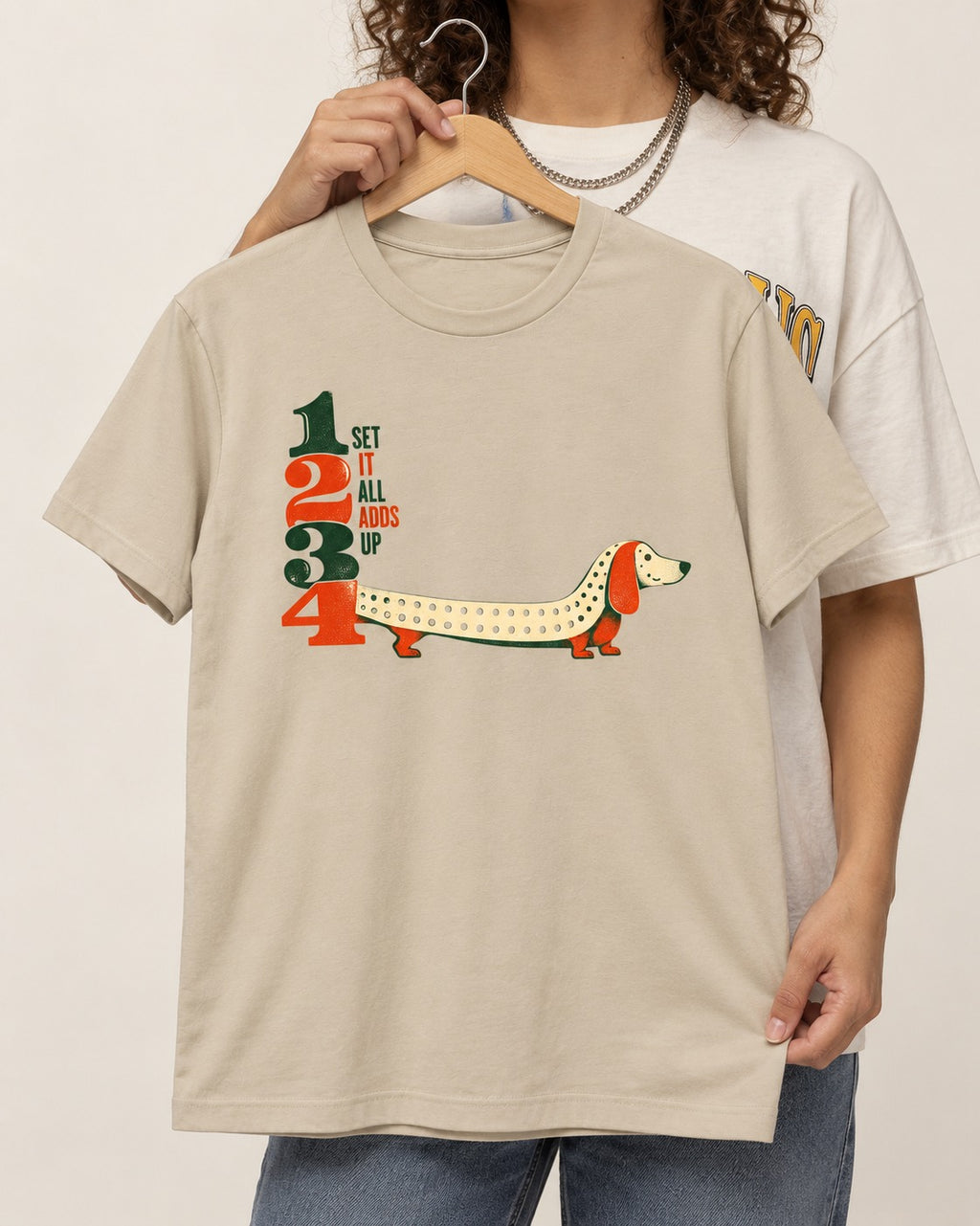 Dachshund Adds Up T-Shirt in Sand, held up on a hanger