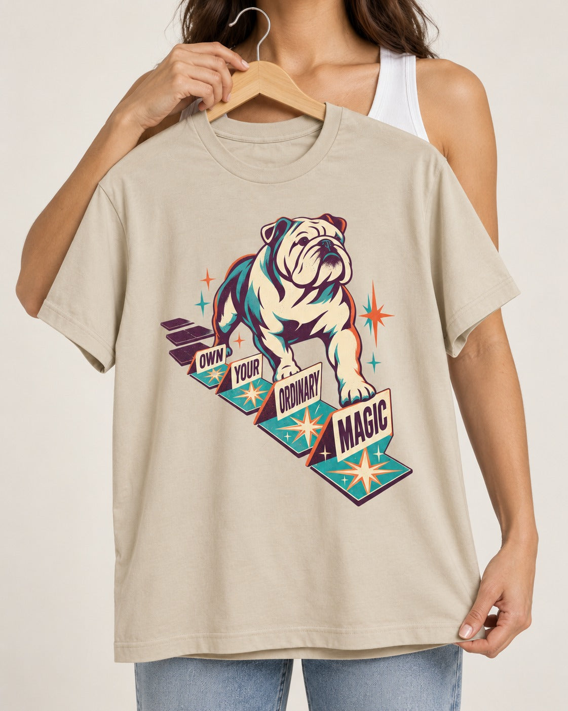 English Bulldog's Ordinary Magic T-Shirt in Sand, held up on a hanger