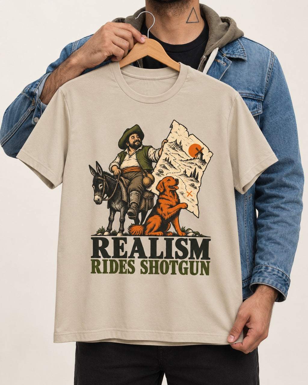 Realism Rides Shotgun with Golden Retriever T-Shirt in Sand, held up on a hanger