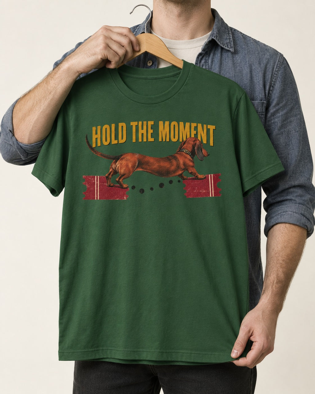 Dachshund Hold The Moment Torn Ticket Bridge Graphic T-Shirt in Forest Green, held up on a hanger