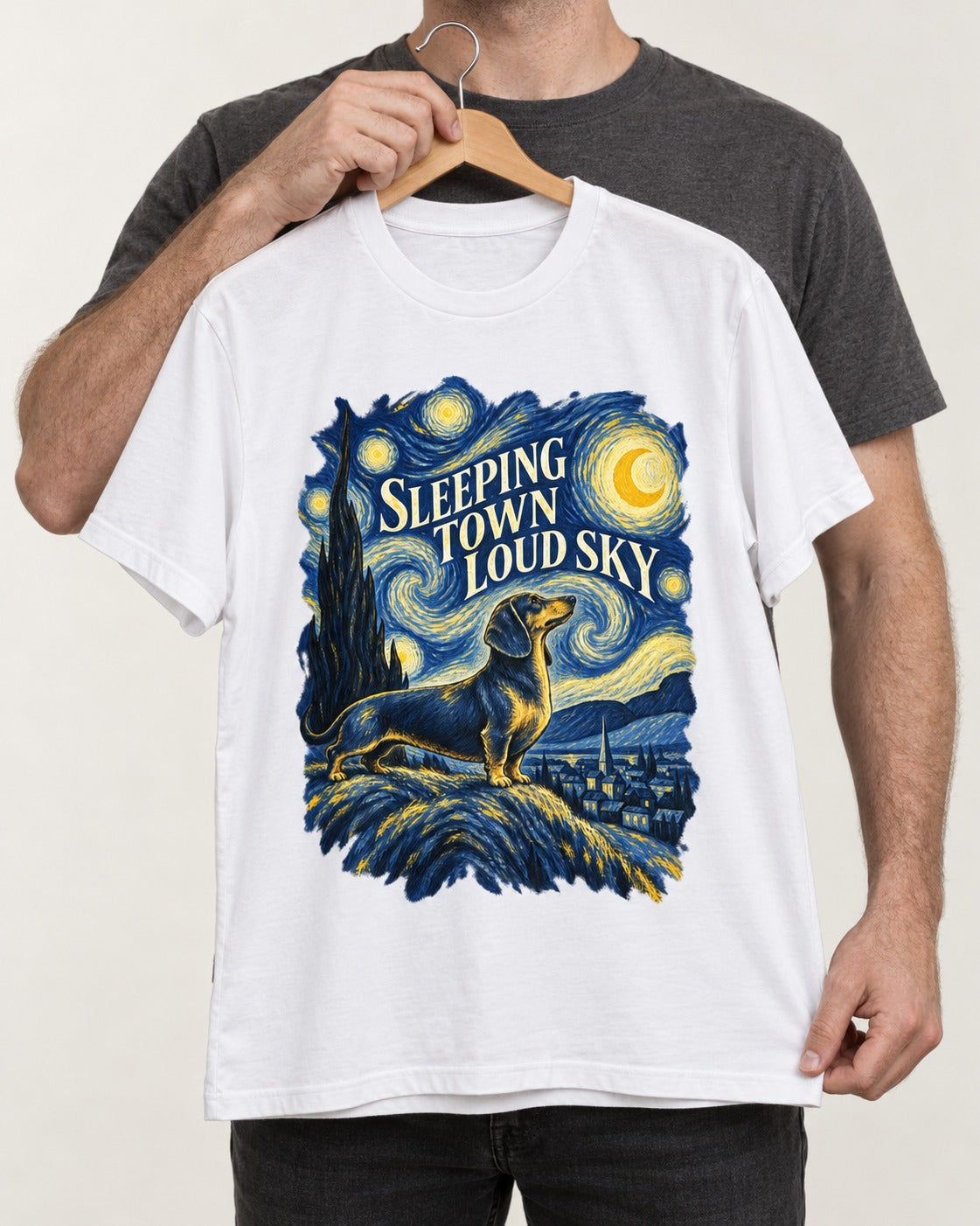Dachshund Sleeping Town Loud Sky Starry Night Graphic T-Shirt in White, held up on a hanger