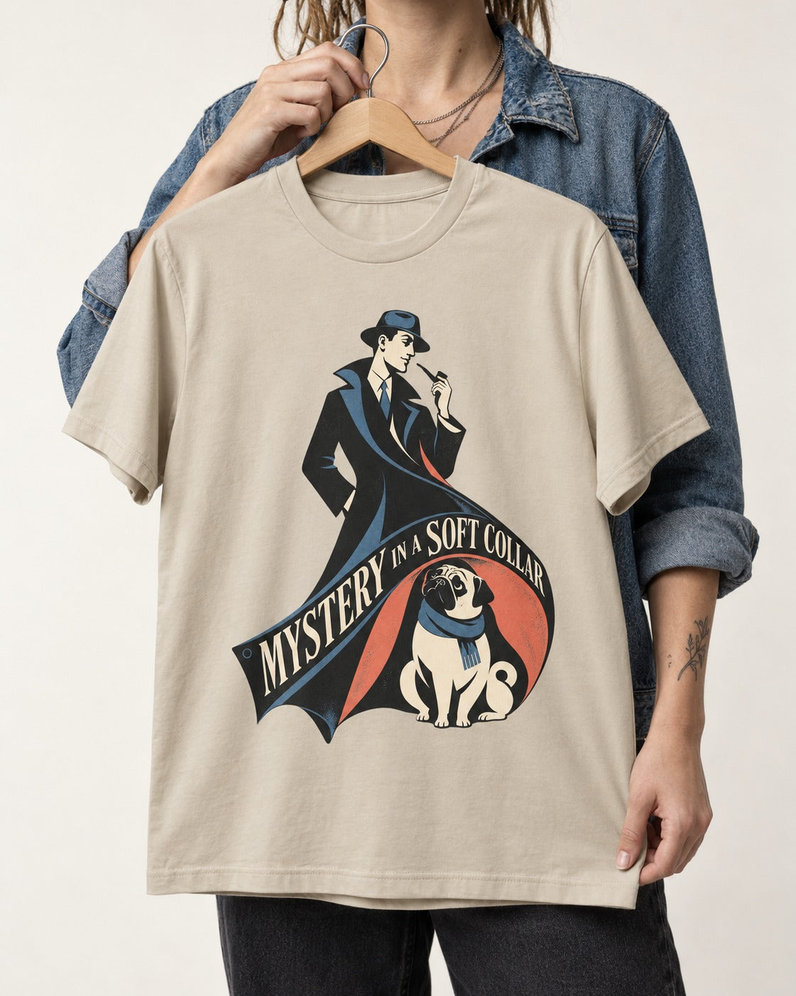 Pug Soft Collar Mystery T-Shirt in Sand, held up on a hanger