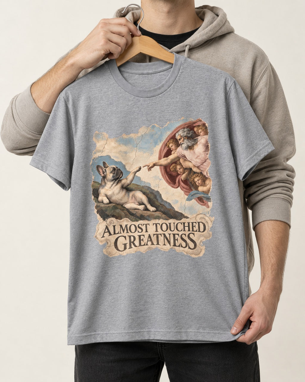 Frenchie Almost Touched Greatness T-Shirt in Sport Grey, held up on a hanger