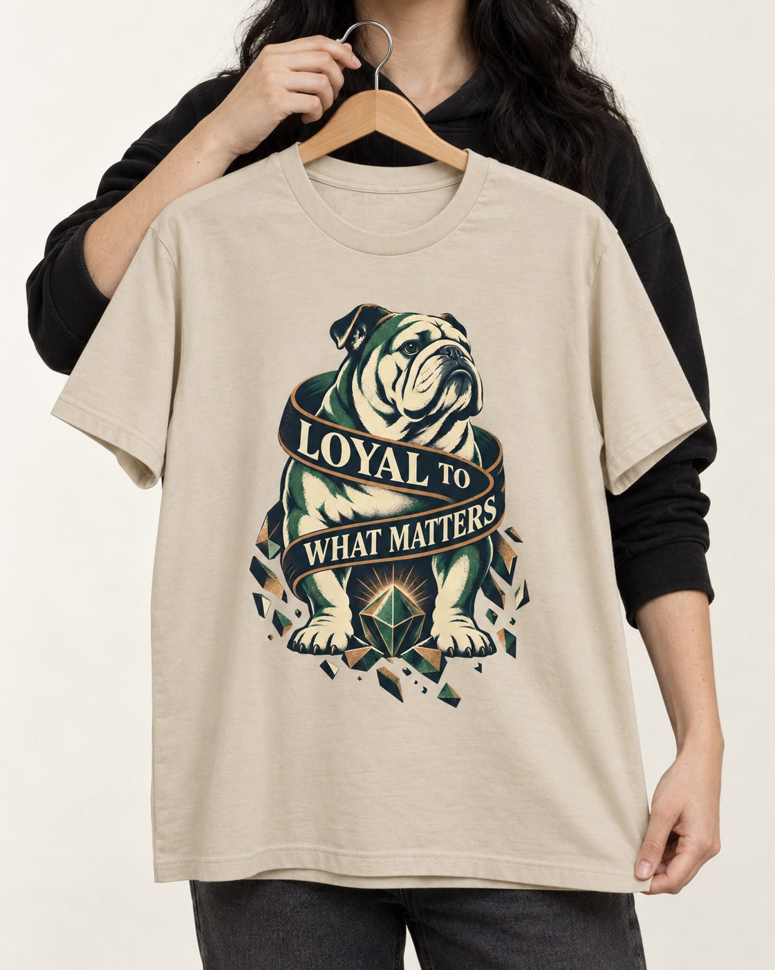 Loyal to What Matters English Bulldog T-Shirt in Sand, held up on a hanger