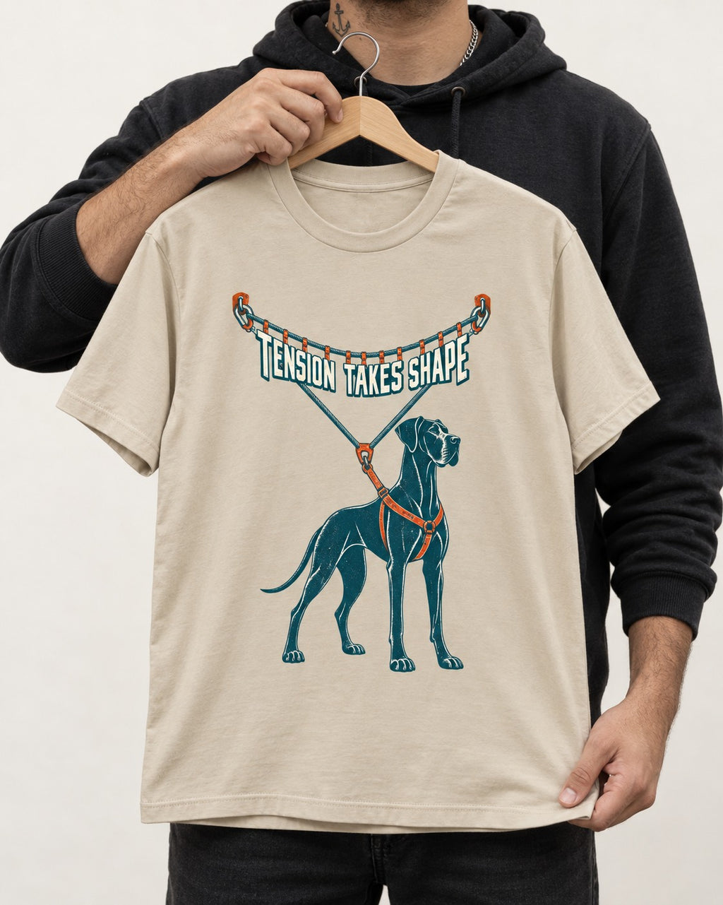 Great Dane Tension Takes Shape T-Shirt in Sand, held up on a hanger
