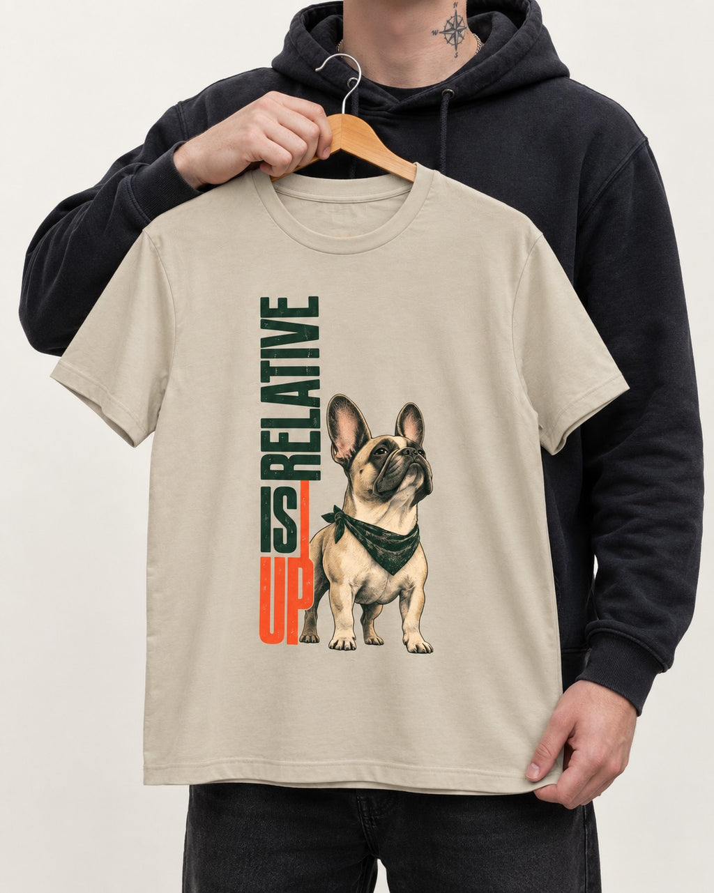 Up Is Relative Frenchie T-Shirt in Sand, held up on a hanger