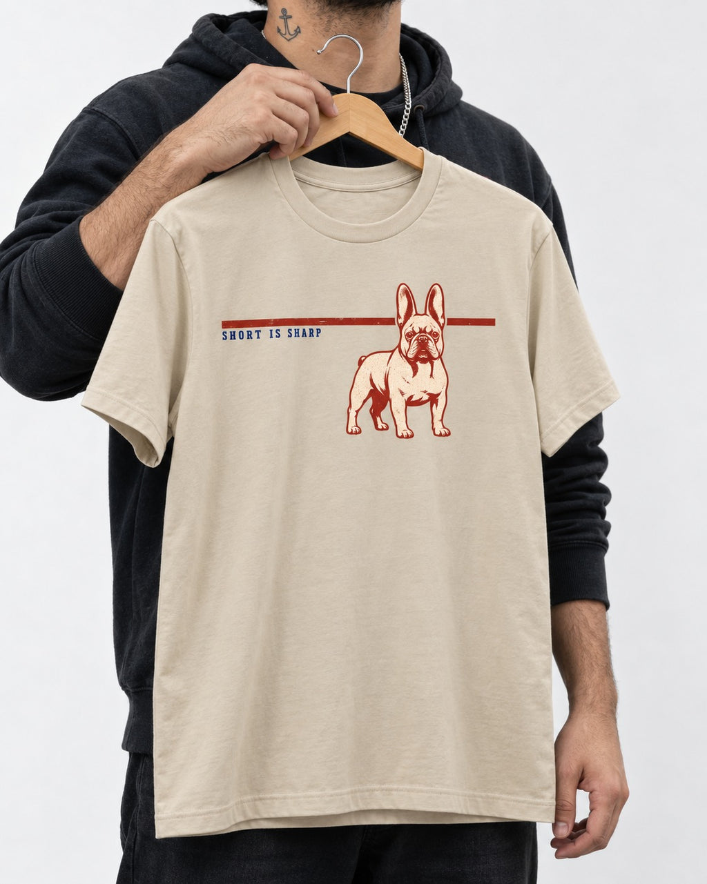 Short Is Sharp Frenchie T-Shirt in Sand, held up on a hanger