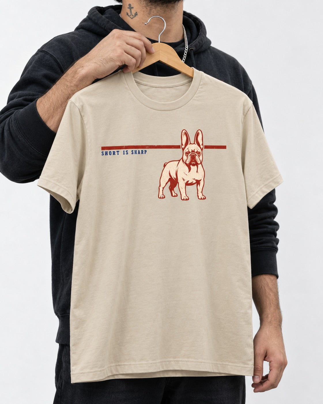 Short Is Sharp Frenchie T-Shirt in Sand, held up on a hanger