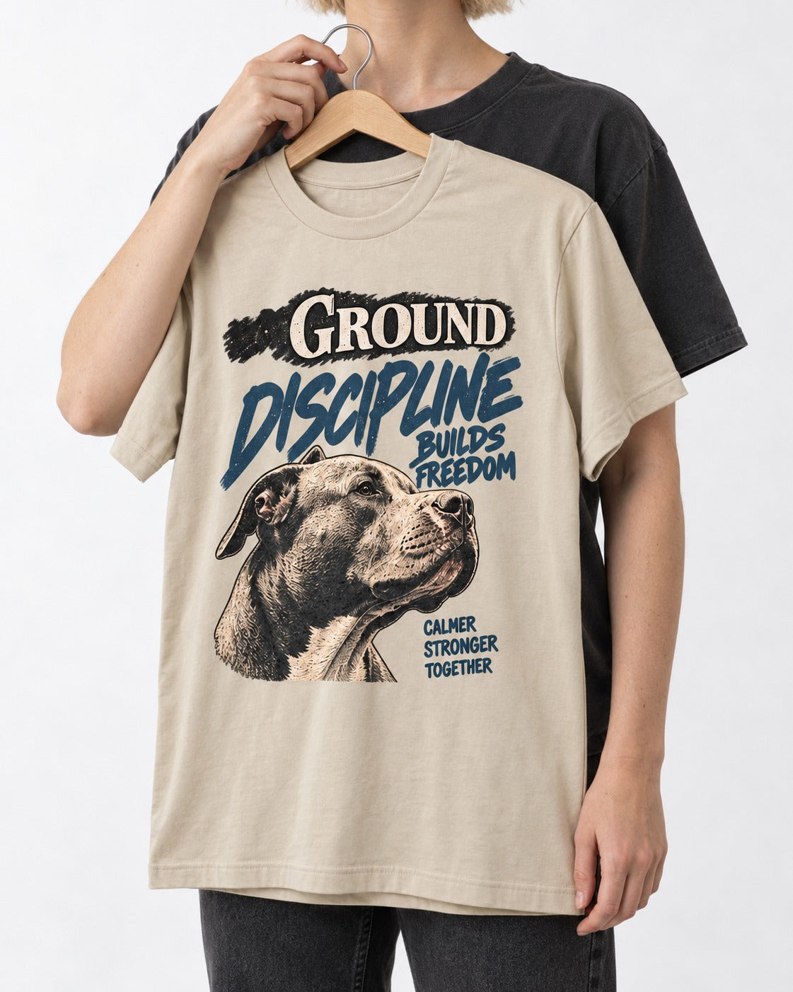 Pitbull Discipline Builds Freedom T-Shirt in Sand, held up on a hanger