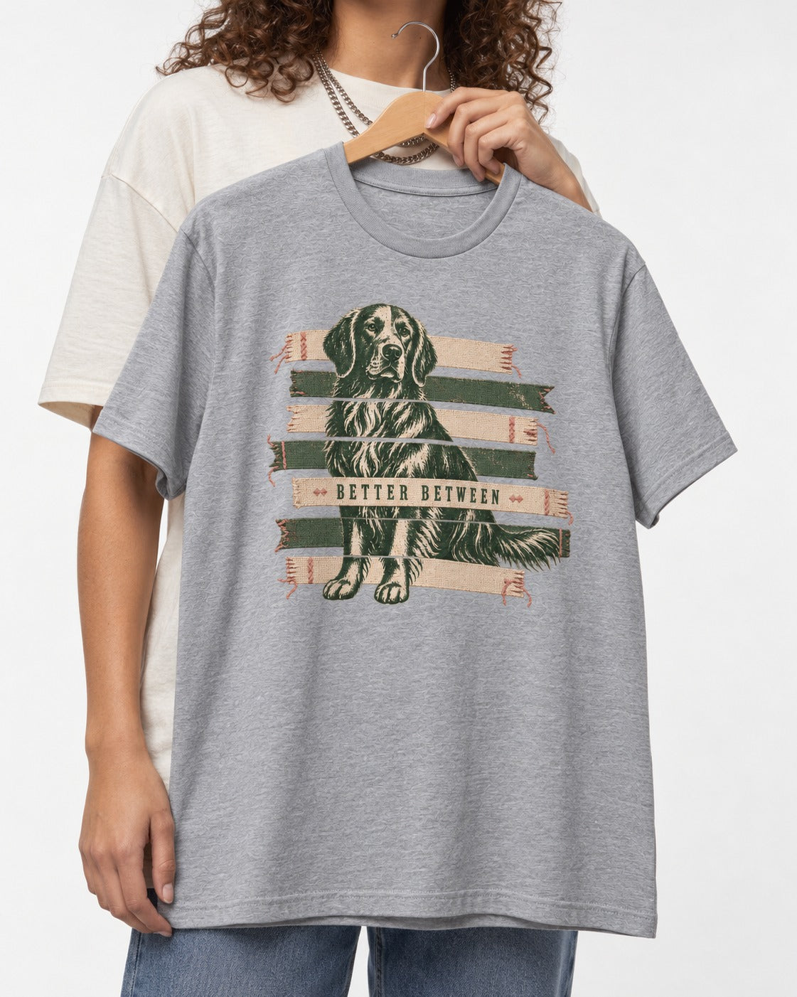 Golden Retriever Better Between T-Shirt in Sport Grey, held up on a hanger