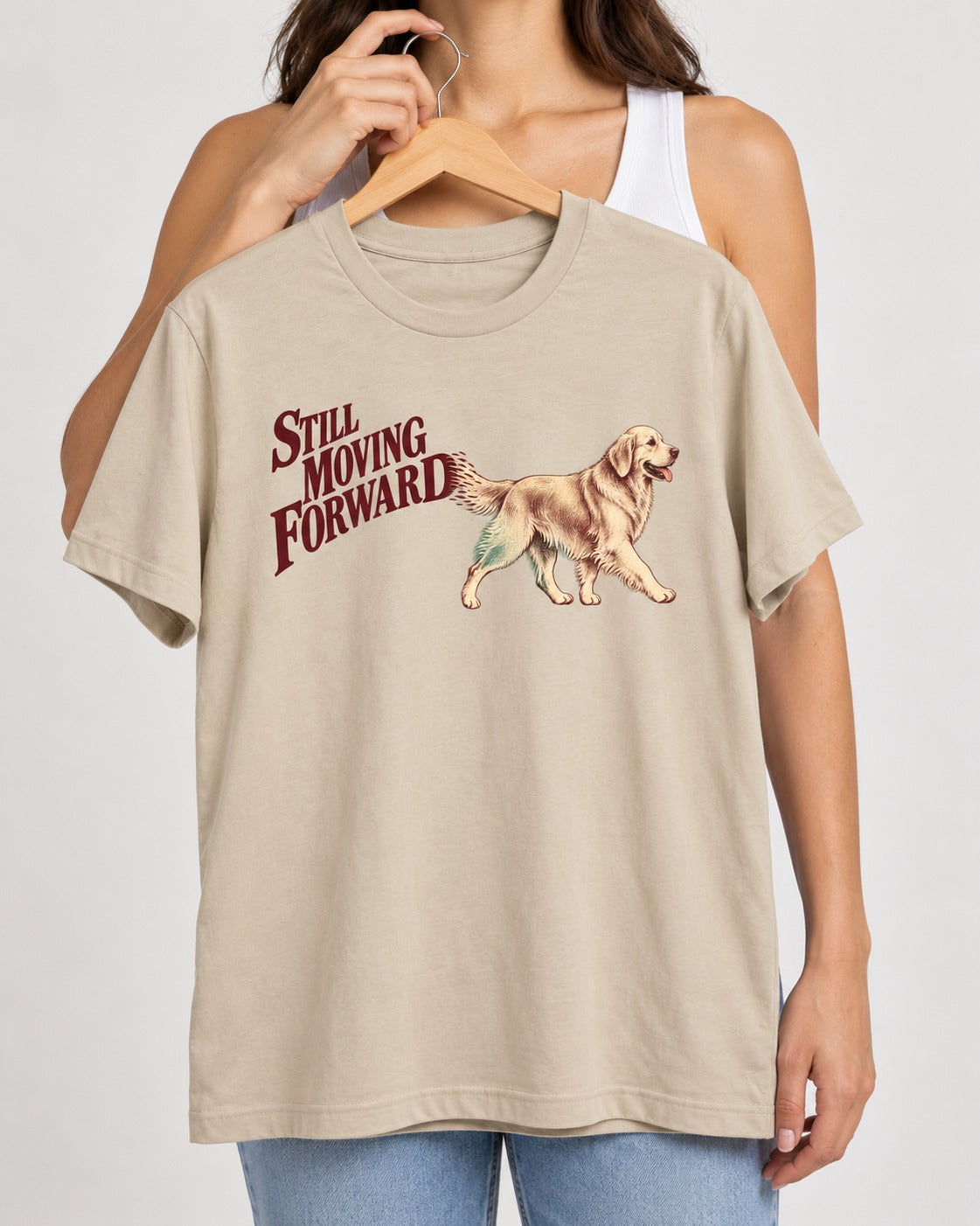 Golden Retriever Still Moving Forward T-Shirt in Sand, held up on a hanger