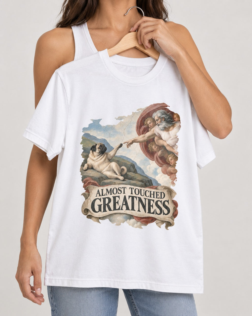 Pug Almost Touched Greatness Creation Parody Graphic T-Shirt in White, held up on a hanger