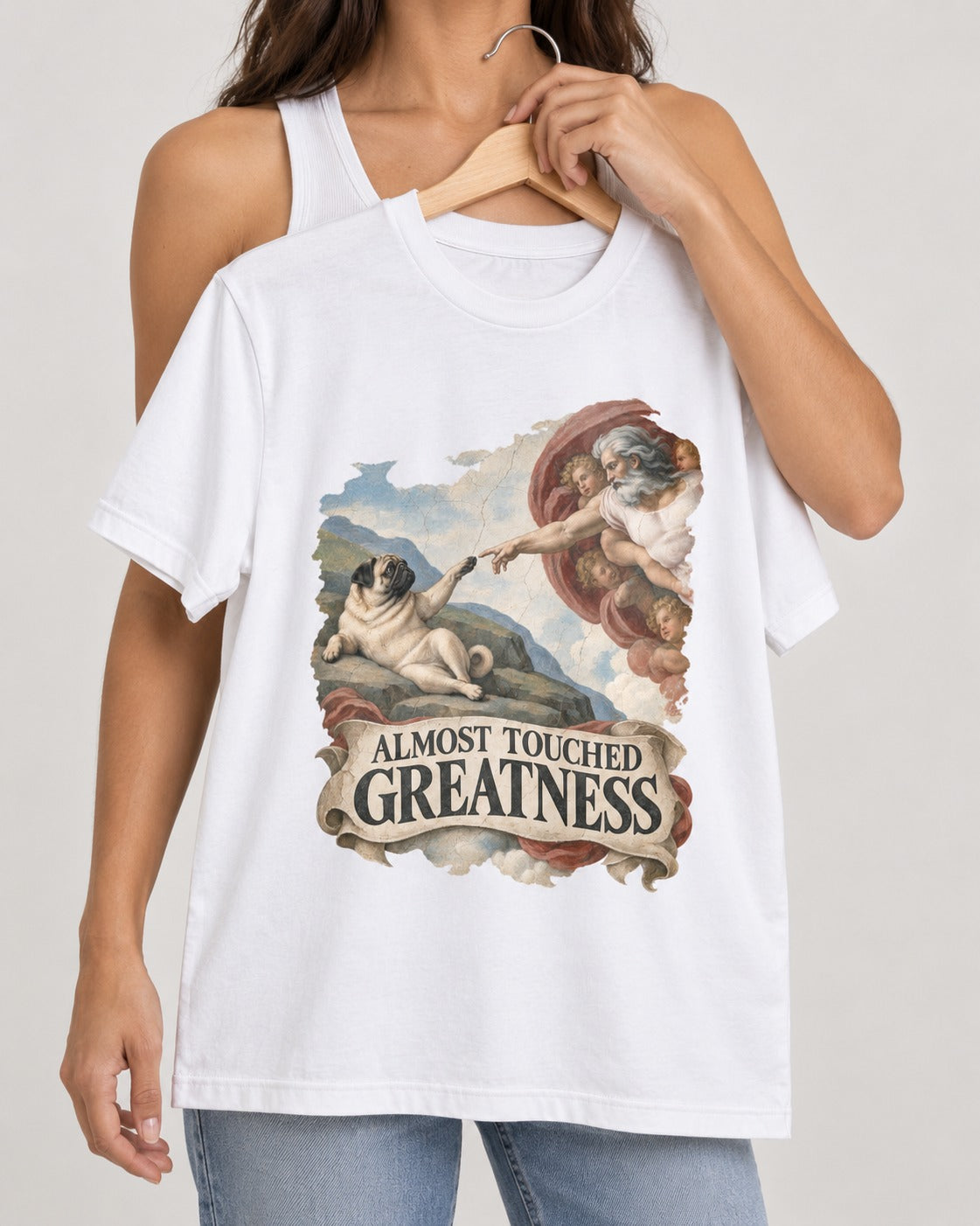 Pug Almost Touched Greatness Creation Parody Graphic T-Shirt in White, held up on a hanger