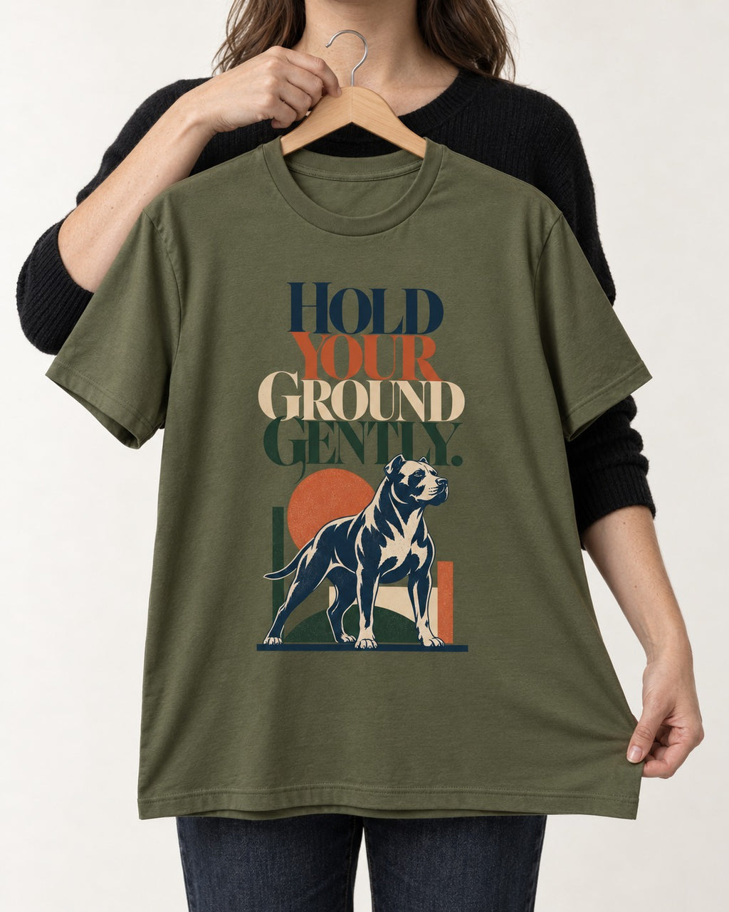Pitbull Hold Your Ground Gently Standing Dog Graphic T-Shirt in Heather Military Green, held up on a hanger