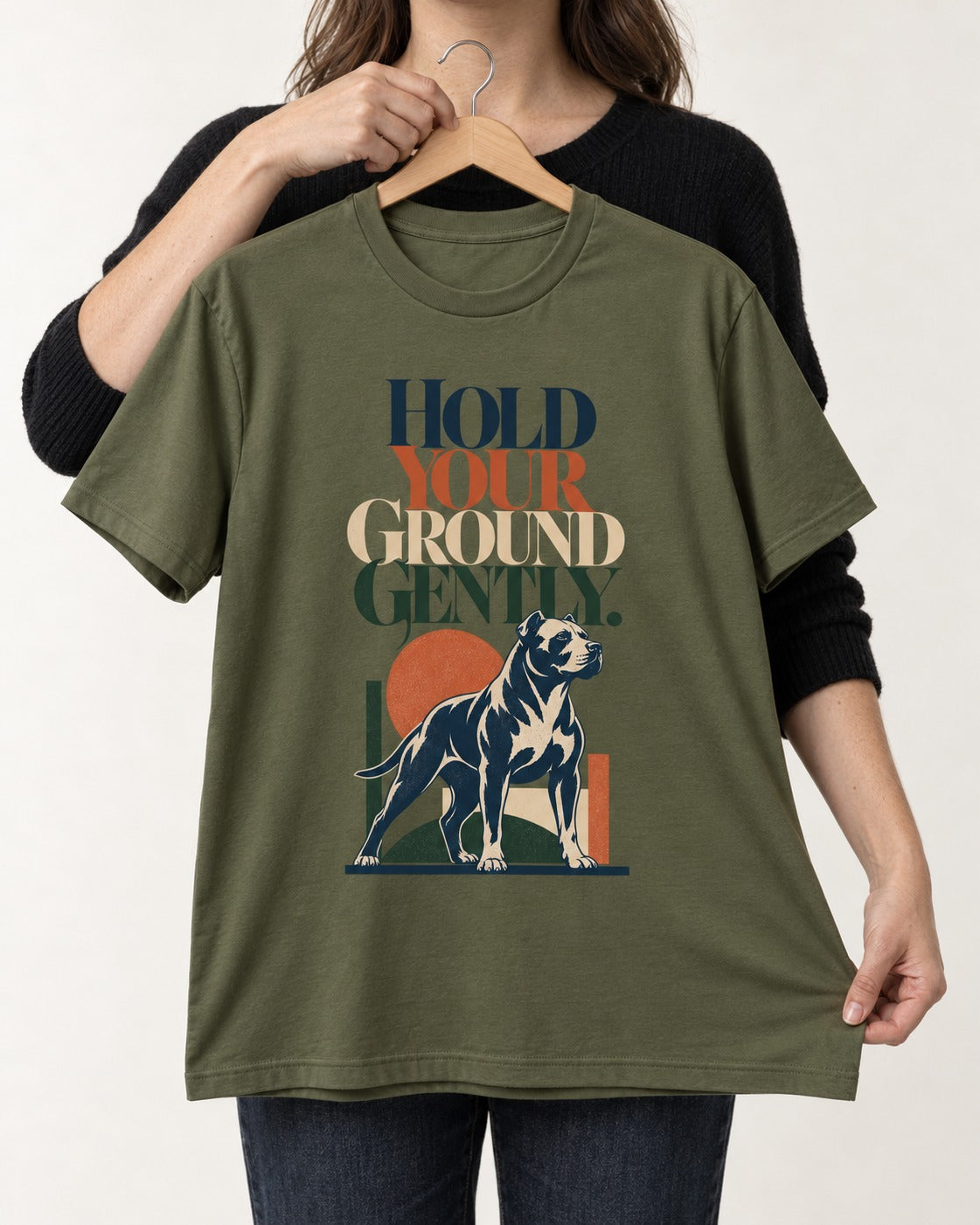 Pitbull Hold Your Ground Gently Standing Dog Graphic T-Shirt in Heather Military Green, held up on a hanger