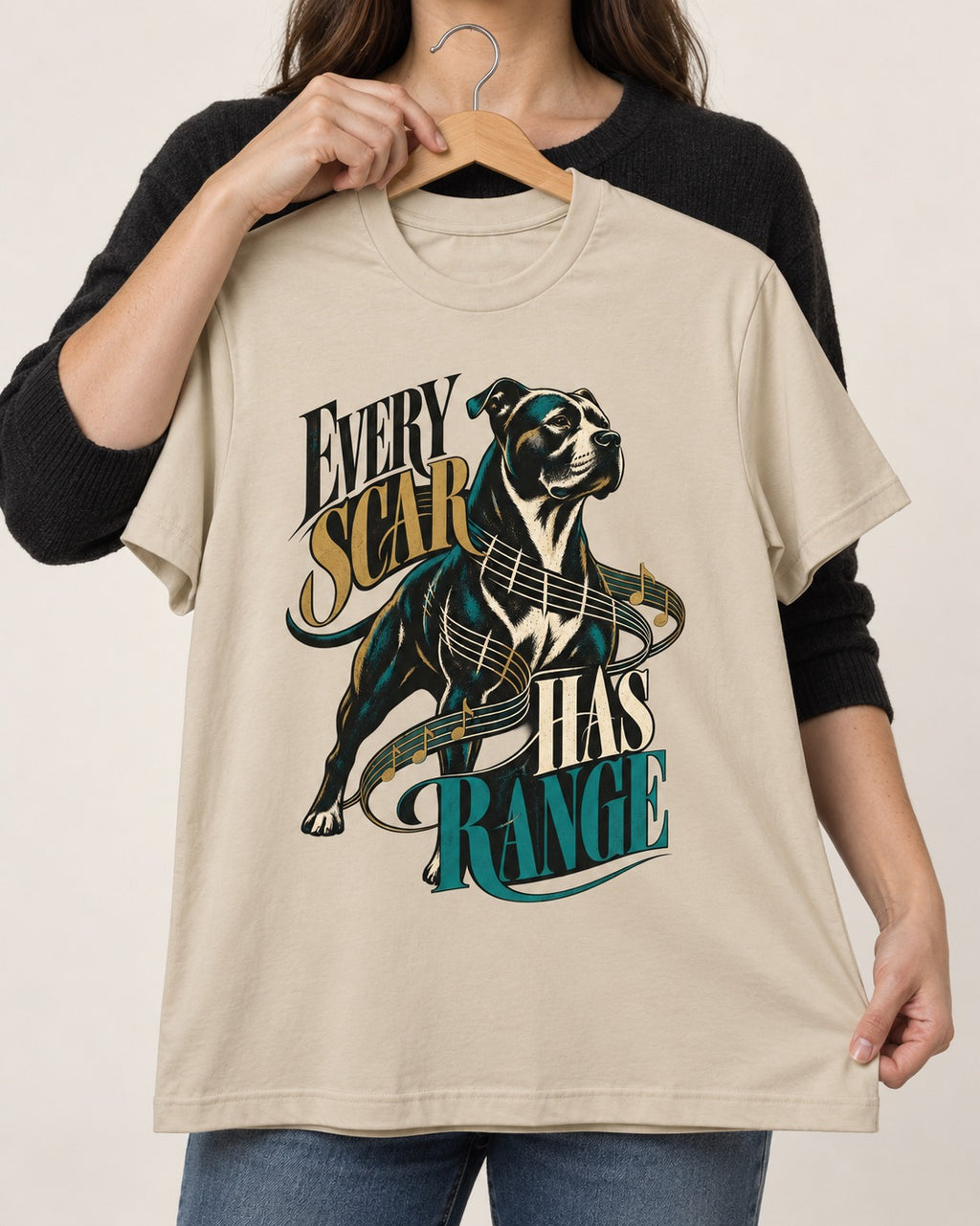 Every Pitbull Scar Has Range T-Shirt in Sand, held up on a hanger