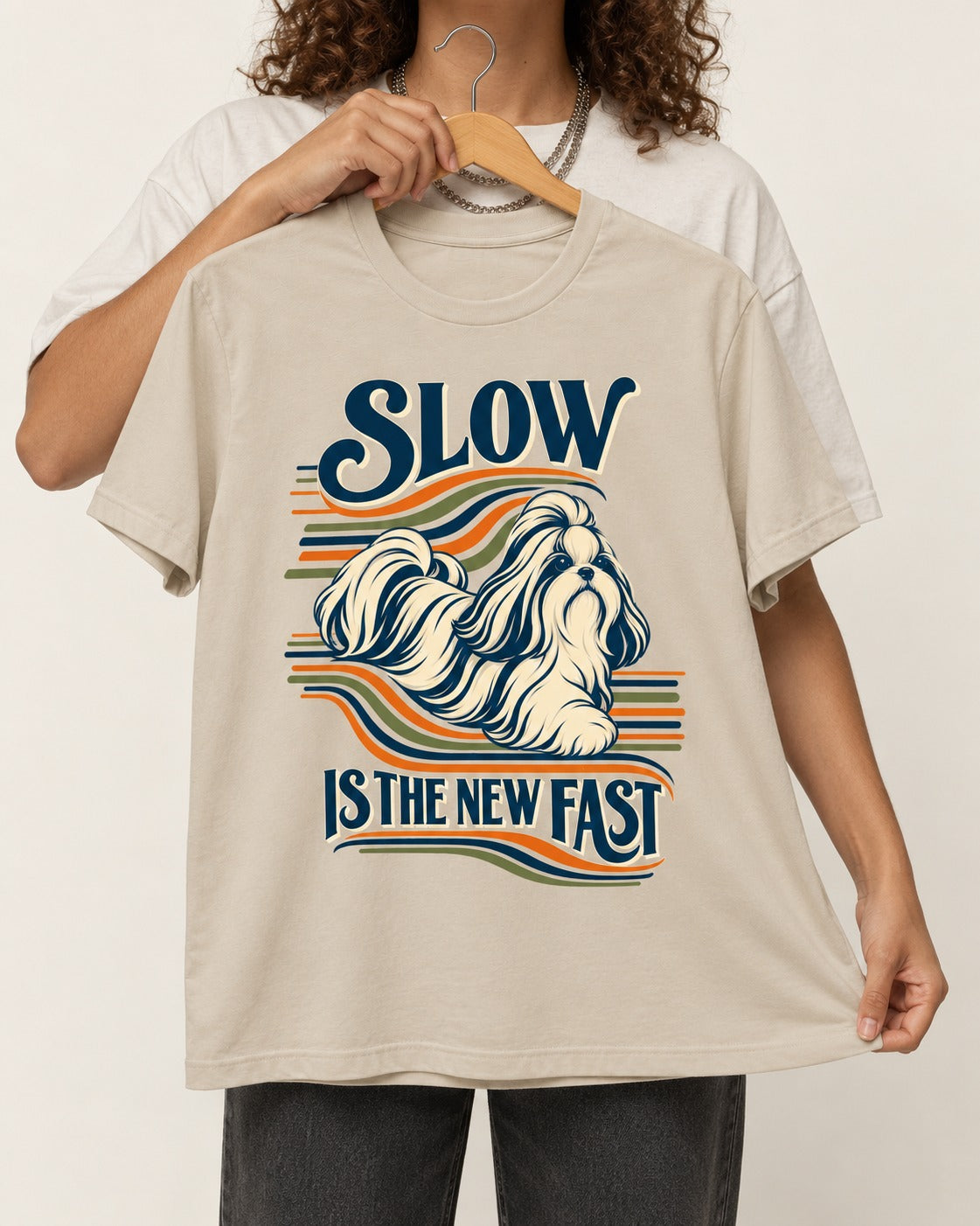 Slow Is Fast Shih Tzu T-Shirt in Sand, held up on a hanger