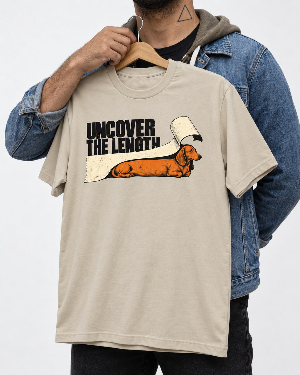 Uncover the Dachshund Length T-Shirt in Sand, held up on a hanger