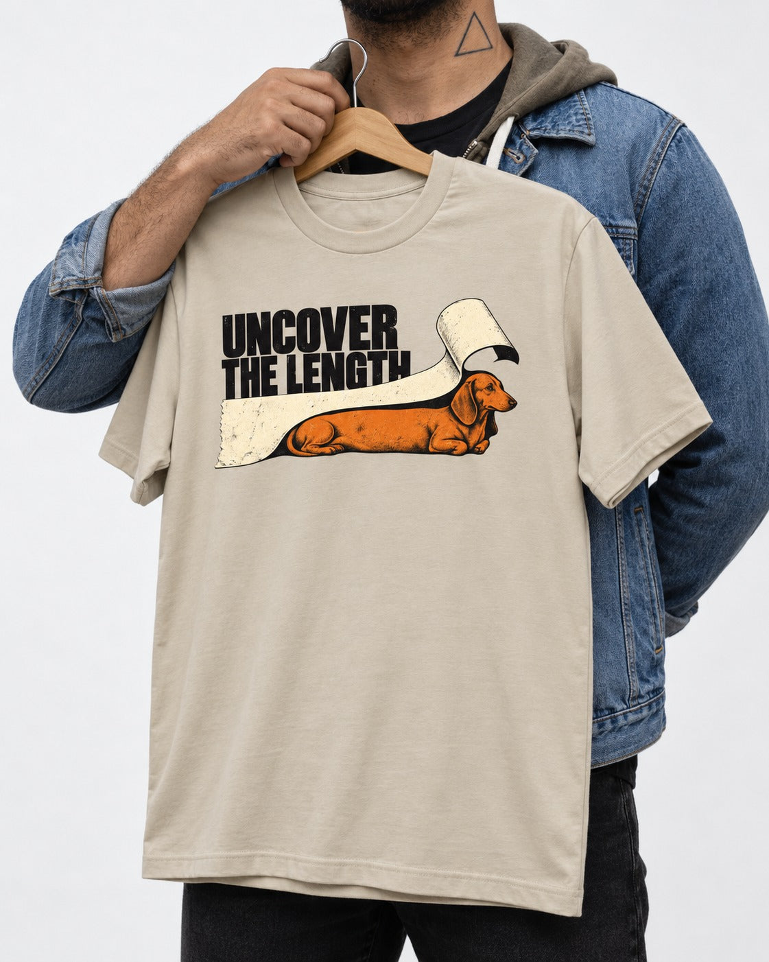 Uncover the Dachshund Length T-Shirt in Sand, held up on a hanger