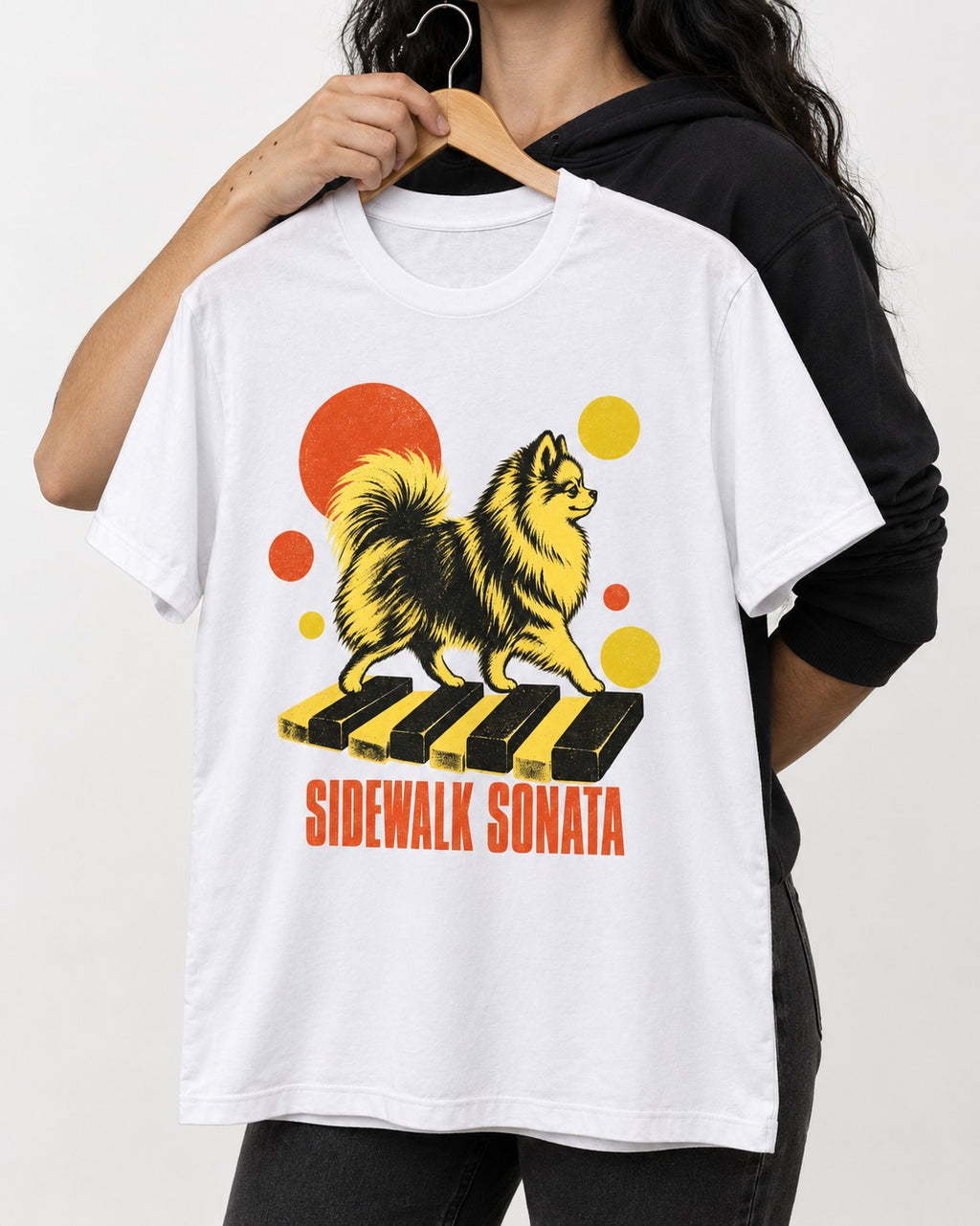 Pomeranian Sidewalk Sonata Piano Graphic T-Shirt in White, held up on a hanger