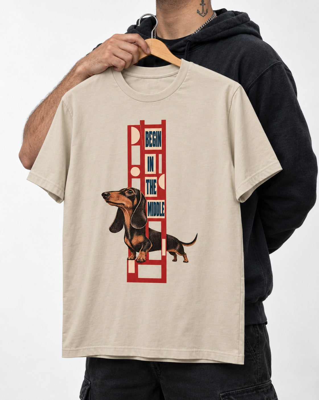 Dachshund Begins in the Middle T-Shirt in Sand, held up on a hanger
