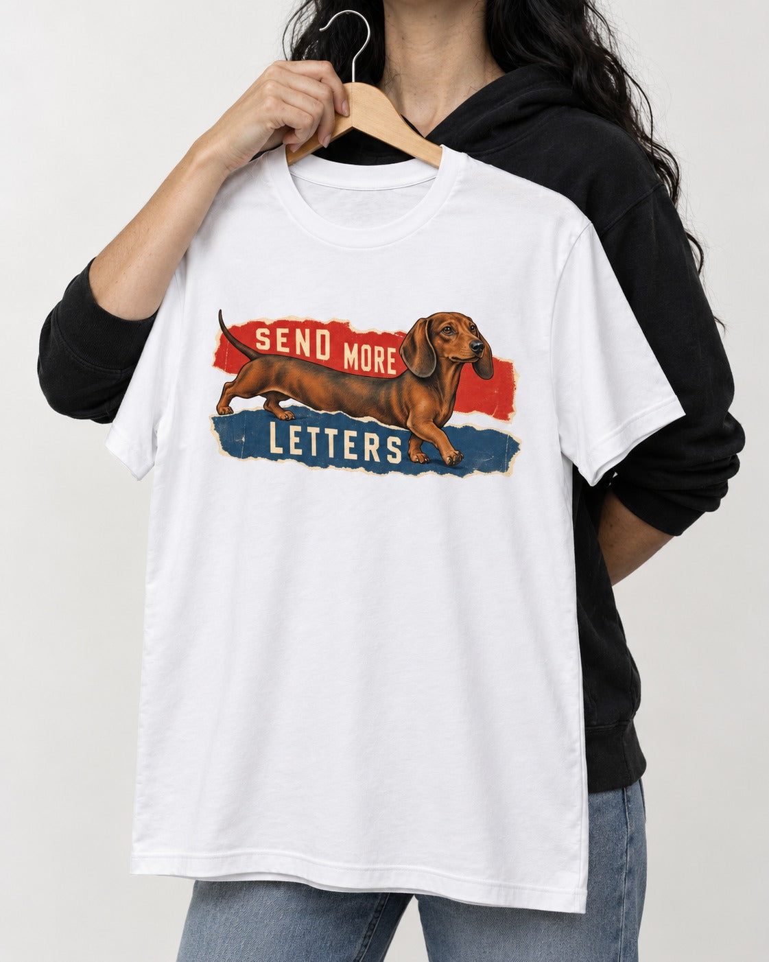Dachshund Send More Letters Torn Paper Graphic T-Shirt in White, held up on a hanger