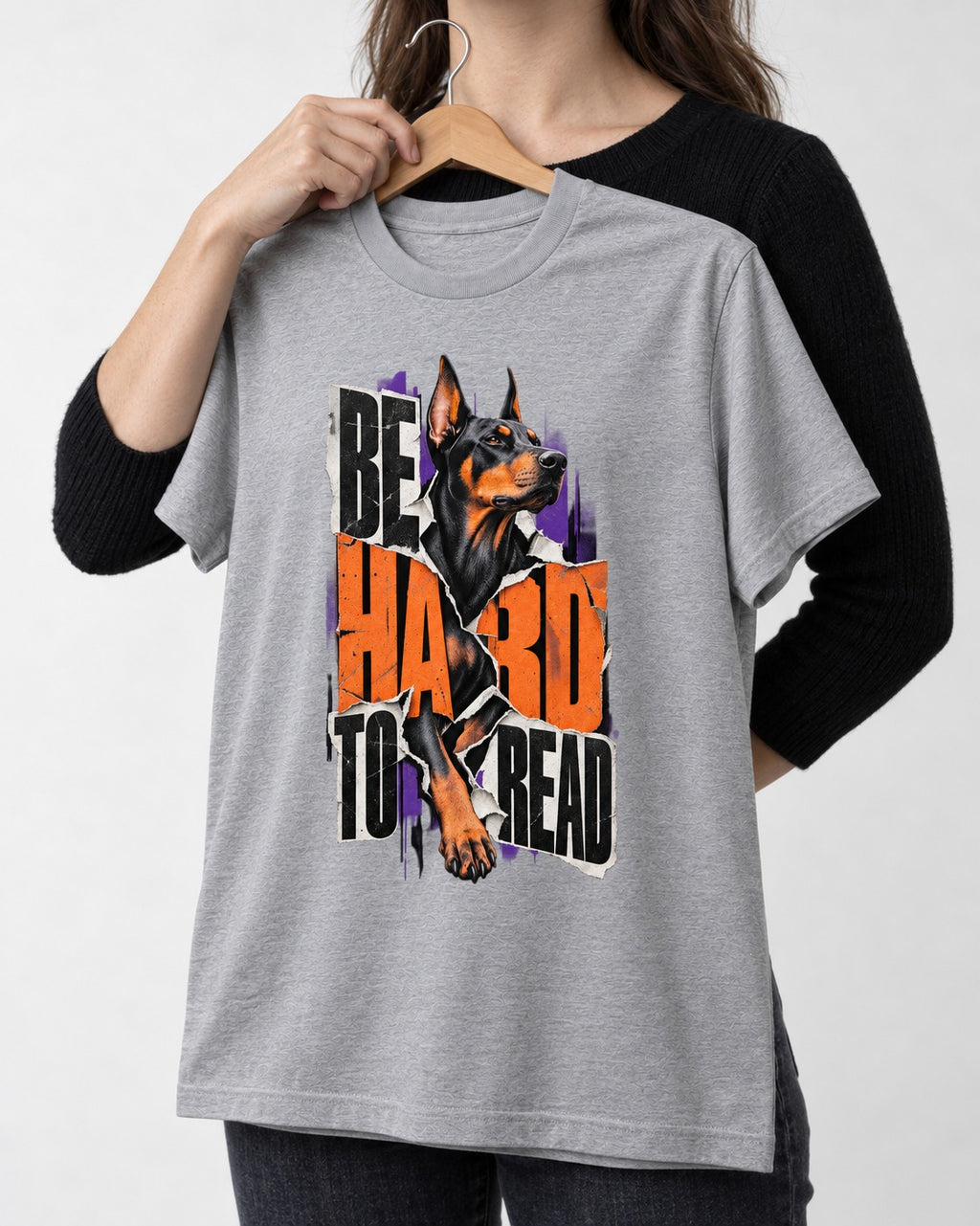 Doberman Be Hard to Read Torn Poster Graphic T-Shirt in Sport Grey, held up on a hanger