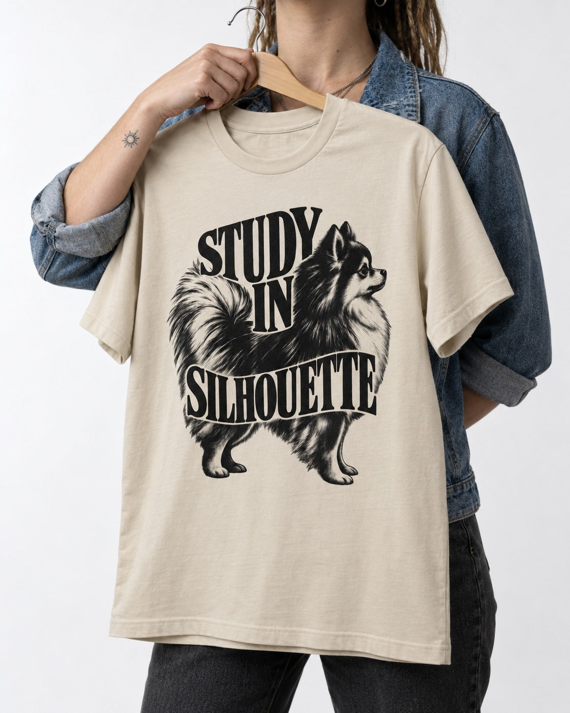 Pomeranian Study in Silhouette T-Shirt in Sand, held up on a hanger