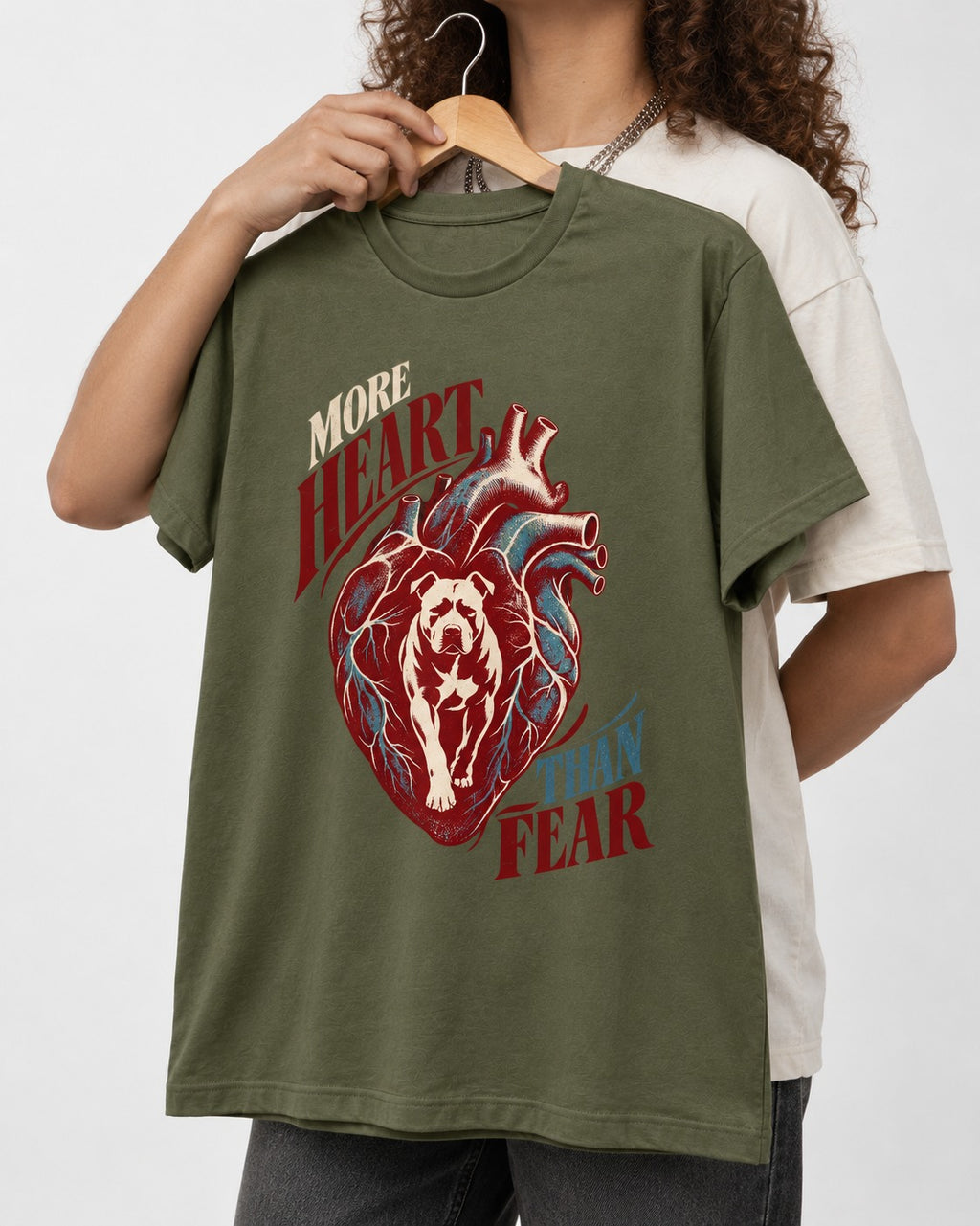 Pitbull More Heart Than Fear Anatomical Heart Graphic T-Shirt in Heather Military Green, held up on a hanger