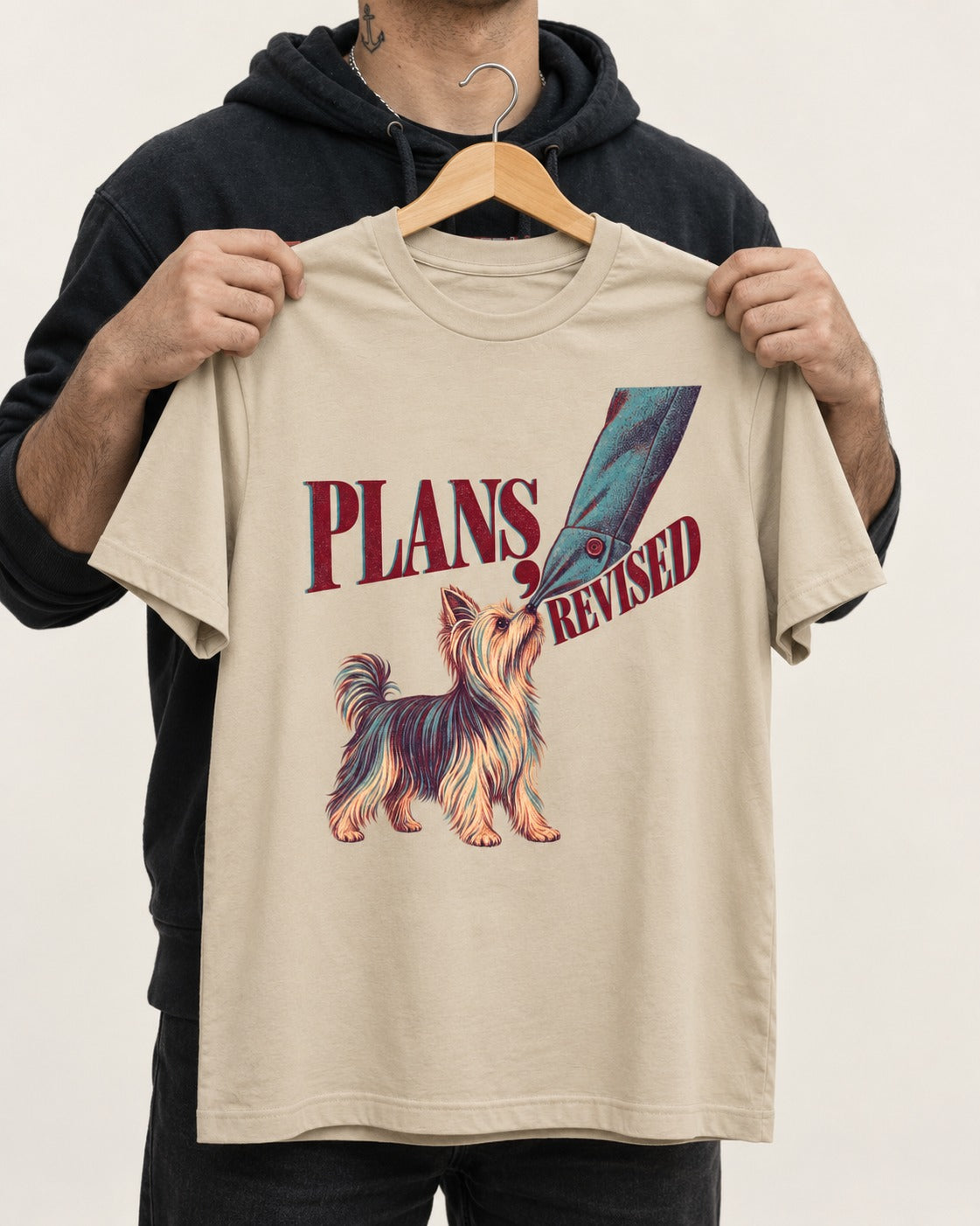 Yorkshire Terrier Plans Revised T-Shirt in Sand, held up on a hanger