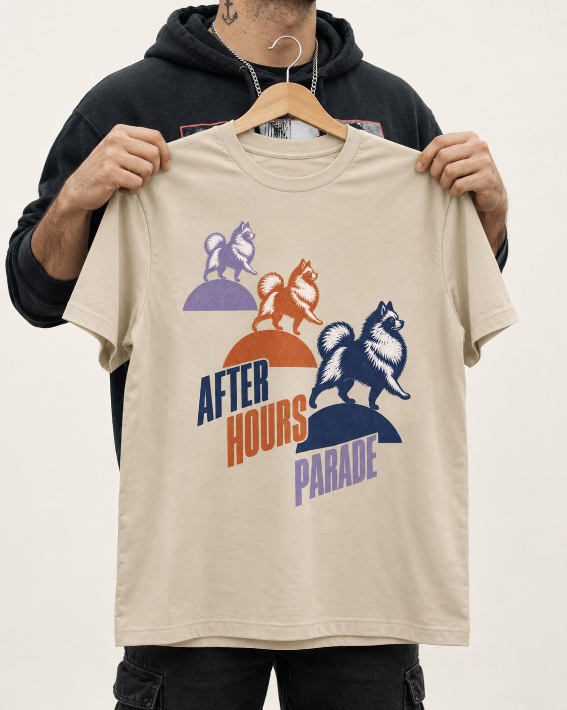 Pomeranian After Hours Parade T-Shirt in Sand, held up on a hanger