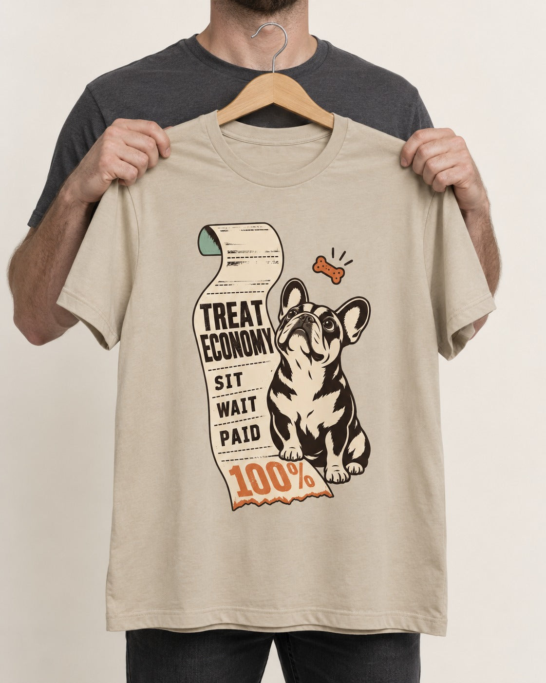Sit Wait Paid Frenchie T-Shirt in Sand, held up on a hanger