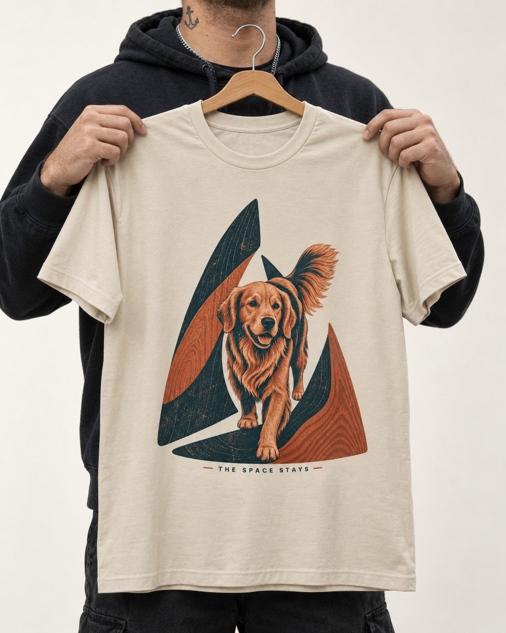 The Golden Retriever Space Stays T-Shirt in Sand, held up on a hanger