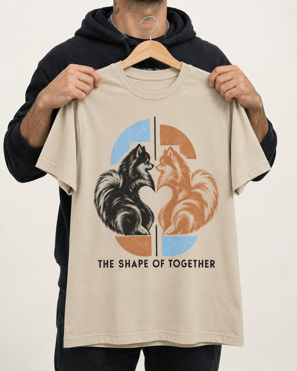 Pomeranian The Shape of Together T-Shirt in Sand, held up on a hanger