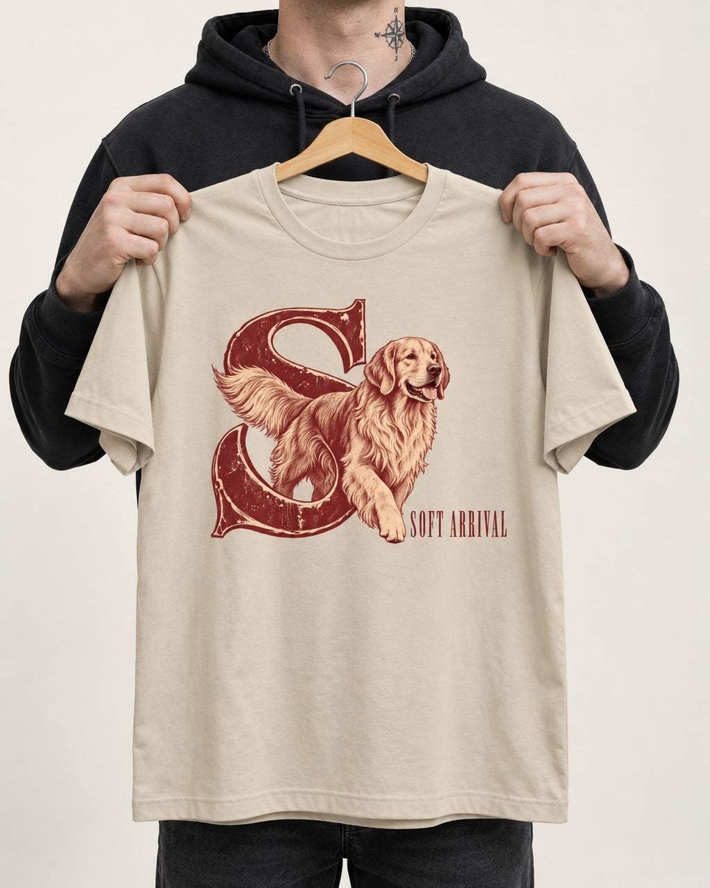 Soft Arrival Golden Retriever T-Shirt in Sand, held up on a hanger