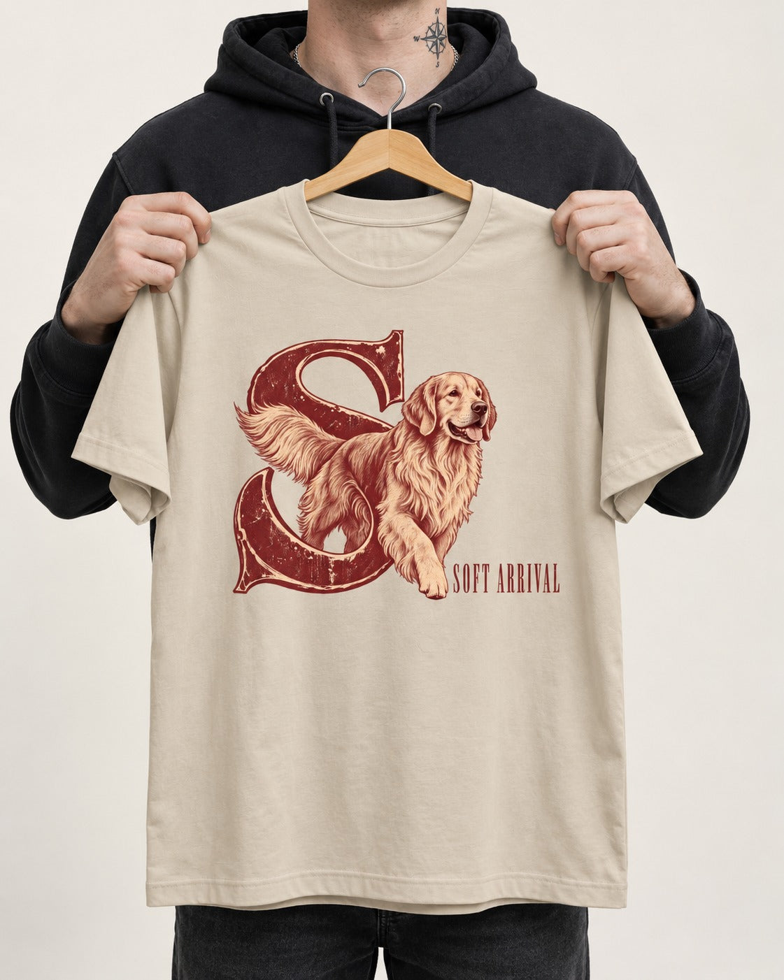 Soft Arrival Golden Retriever T-Shirt in Sand, held up on a hanger