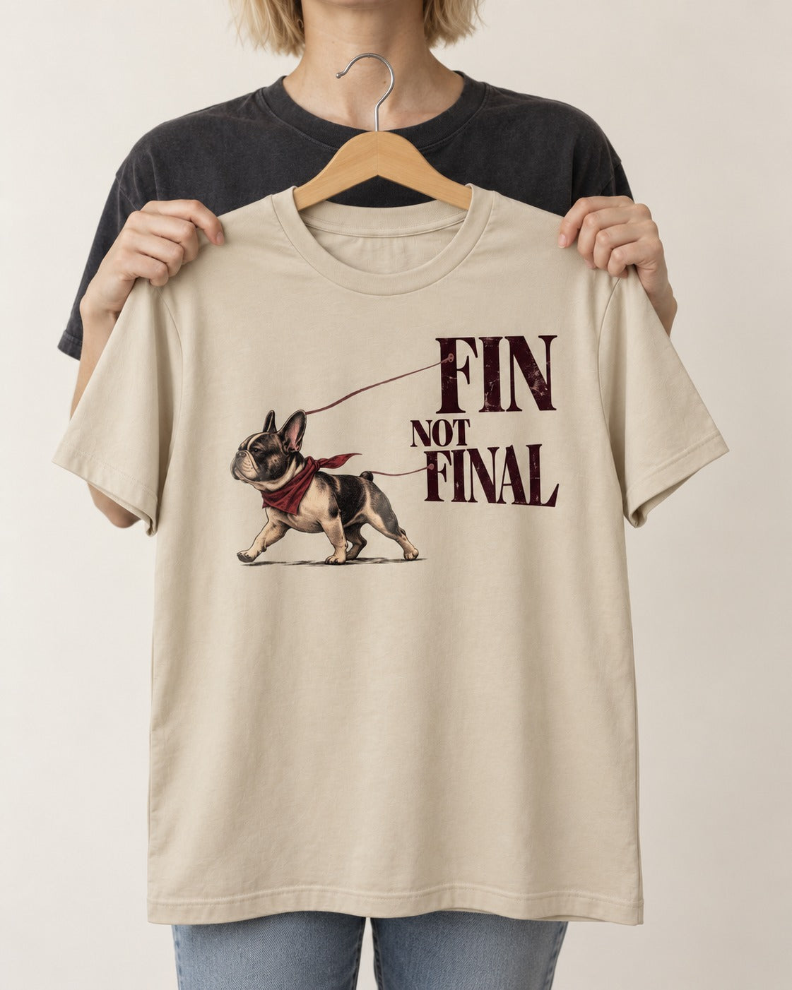 Frenchie Fin Not Final T-Shirt in Sand, held up on a hanger