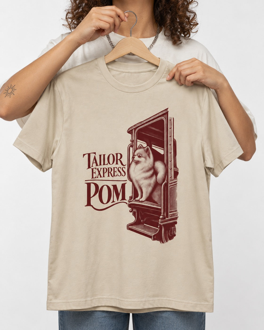 Pomeranian Express T-Shirt in Sand, held up on a hanger