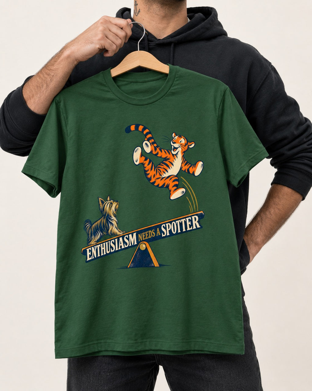 Yorkshire Terrier Enthusiasm Needs a Spotter Seesaw Graphic T-Shirt in Forest Green, held up on a hanger
